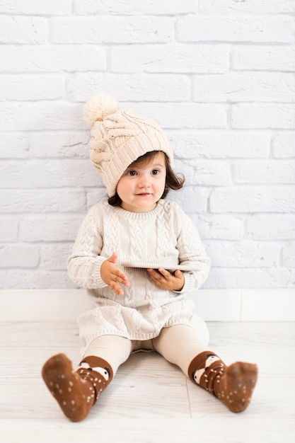 Foto gratuita bambina adorabile che tiene un telefono