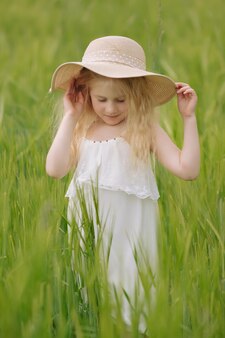 暖かい夏の日に麦畑で遊ぶ愛らしい少女