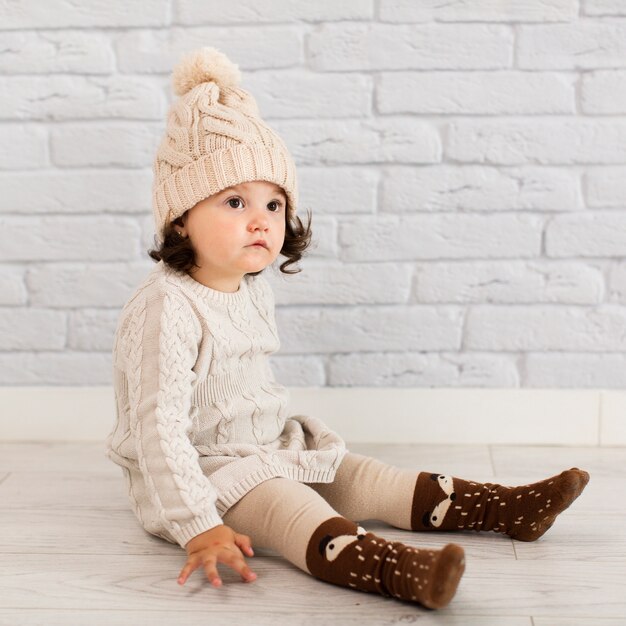 Adorable little girl sitting on floor