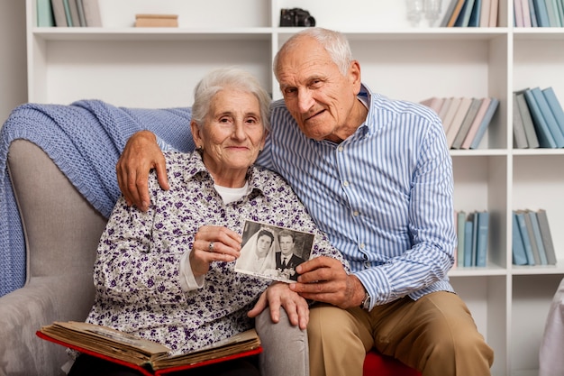 Adorable mature man and woman holding wedding picture