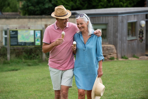 屋外で一緒にアイスクリームを楽しんでいる愛らしい年配のカップル