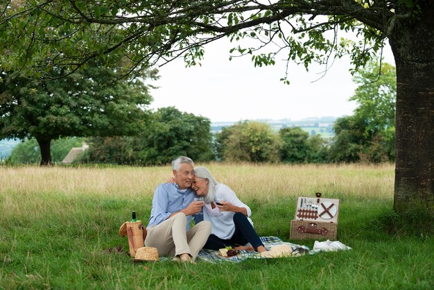 屋外でピクニックをしている愛らしい年配のカップル