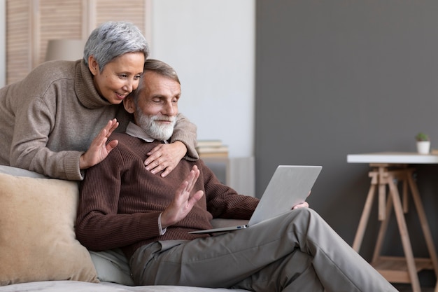 Adorable senior couple video conferencing