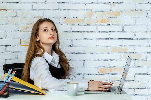 An adorable student sitting behind the desk and thinking High quality photo