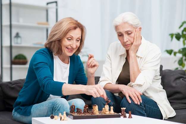 Adorable women playing chess together