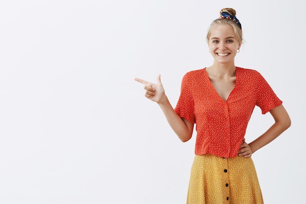 Adorable young blond girl posing against the white wall