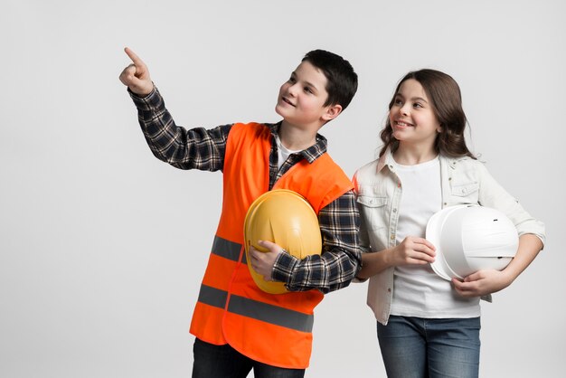 Adorable young boy and girl holding hard hats