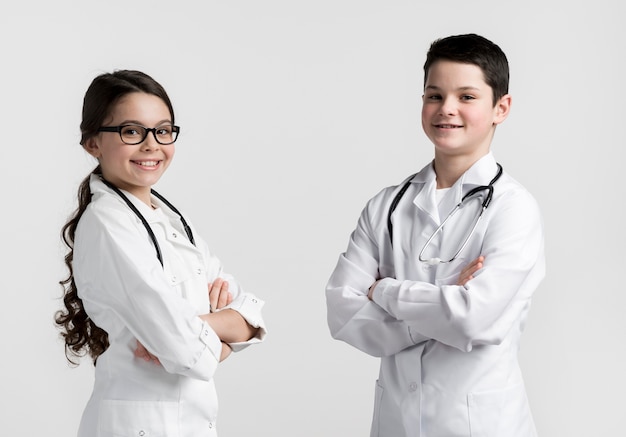 Adorable young boy and girl posing as doctors