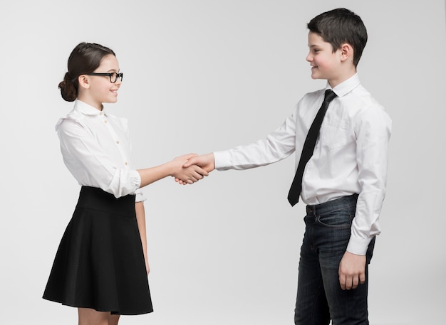 Adorable young boy and girl shaking hands