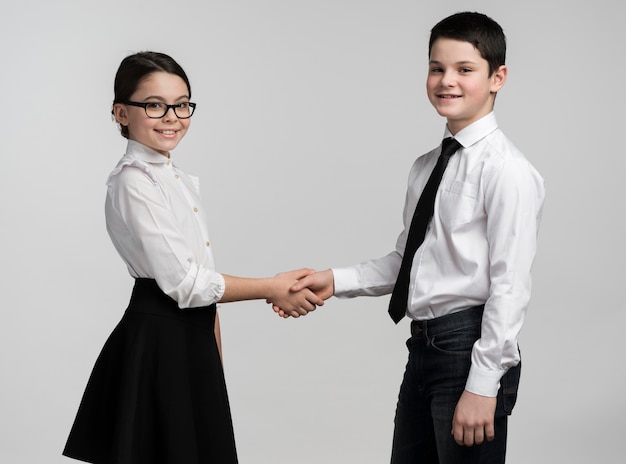 Adorable young boy and girl shaking hands