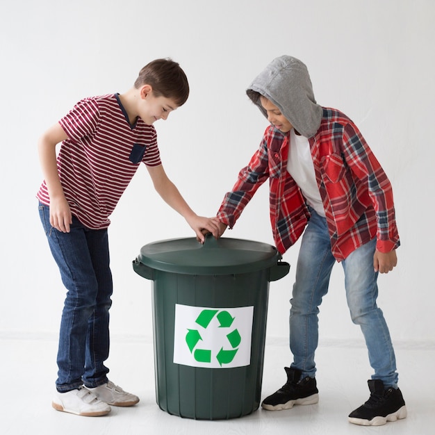 Adorable young boys touching recycle bin
