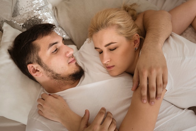 Free photo adorable young couple together in bed