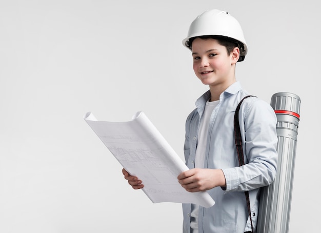 Adorable young engineer holding construction plan