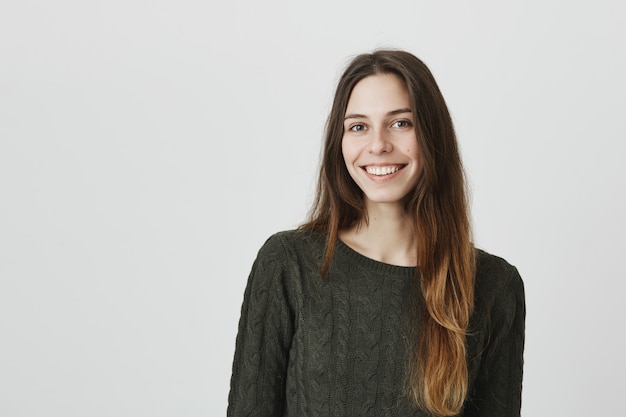 Adorable young female with long hair, smiling at camera