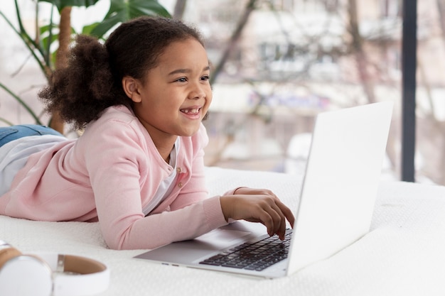 Free photo adorable young girl browsing a laptop
