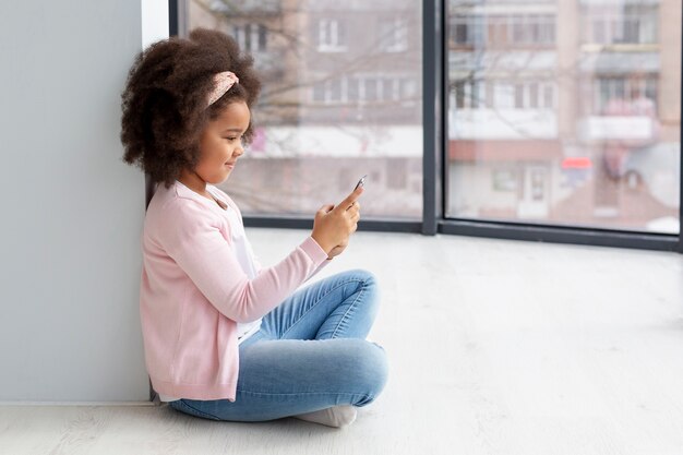 Очаровательная молодая девушка просматривает мобильный телефон