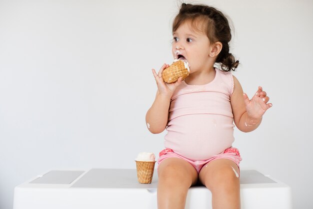 Очаровательная молодая девушка ест мороженое
