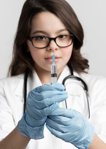 Adorable young girl preparing medical syringe