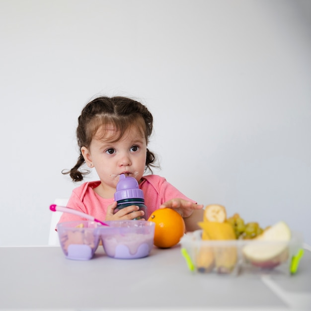 Adorable young girl with a fruit bowl