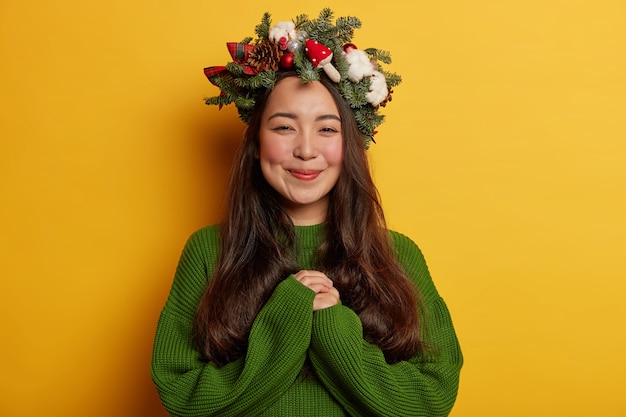 愛らしいお嬢様がお祭りの花輪を頭にかぶって気持ちよく微笑む