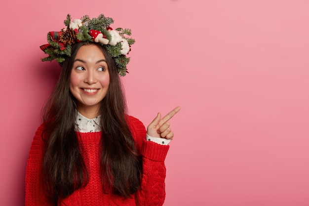 Adorable young lady smiles pleasantly wearing festive wreath on head