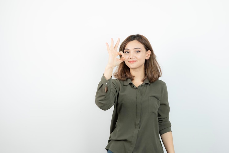 無料Photo 立ってポーズをとってカジュアルな服装で愛らしい若い女性。高品質の写真