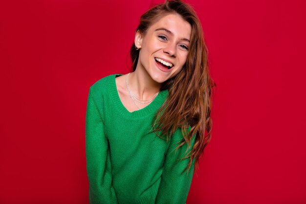 Adorable young woman in winter outfit in studio. Inspired lady has fun and posing at camera isolated on bright background