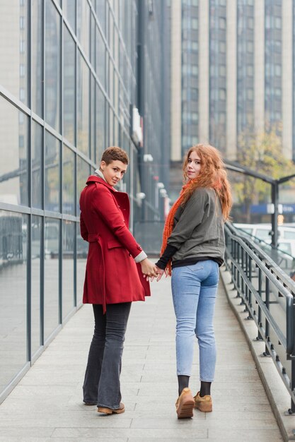 Adorable young women holding hands