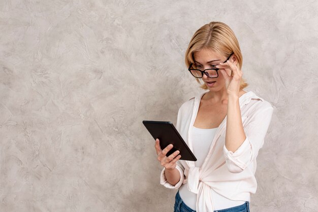 Adult blonde woman checking her tablet