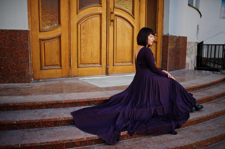 Free Photo adult brunette woman at violet gown background old wooden doors