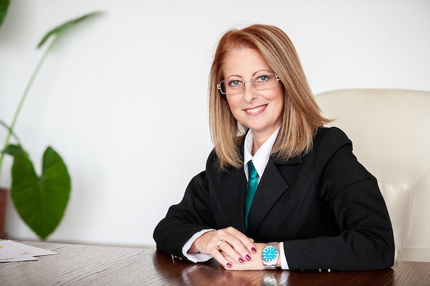 Free photo adult businesswoman in her 40 s smiling at the camera in her office