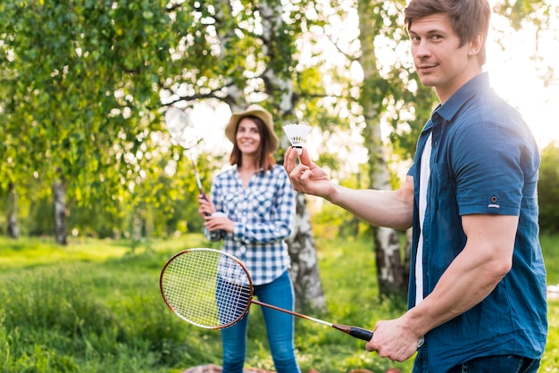 Free photo adult couple playing badminton in park