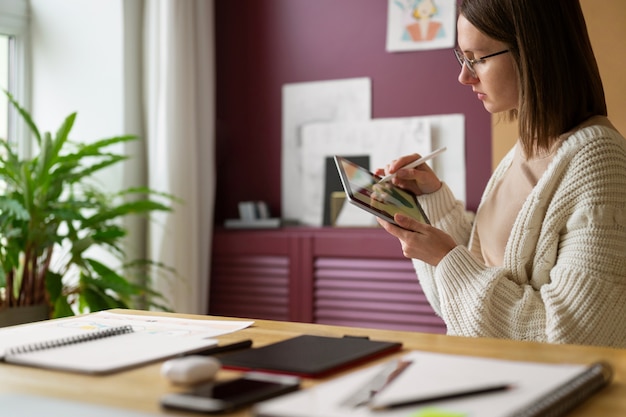 Adult female illustrator working on tablet device