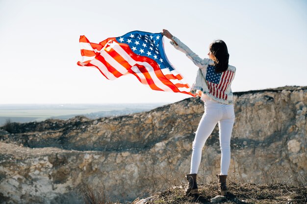 Adult female raising hands with USA flag
