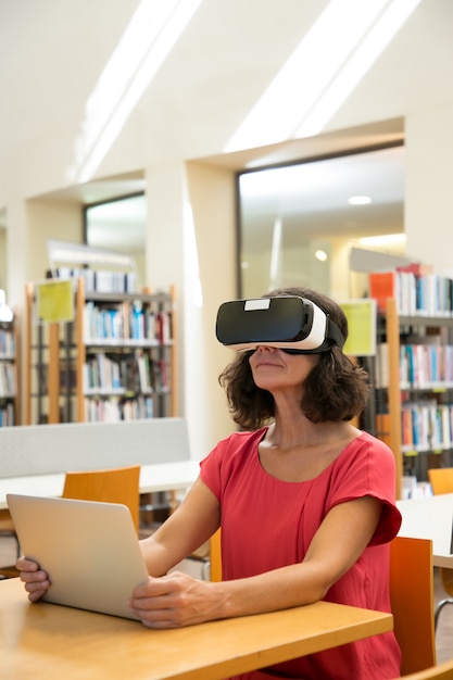 Adult female student watching virtual video tutorial