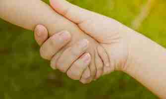 Free photo adult hand grabbing a baby hand