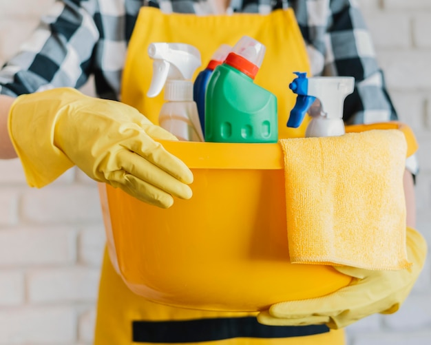 Adult holding basket with cleaning products