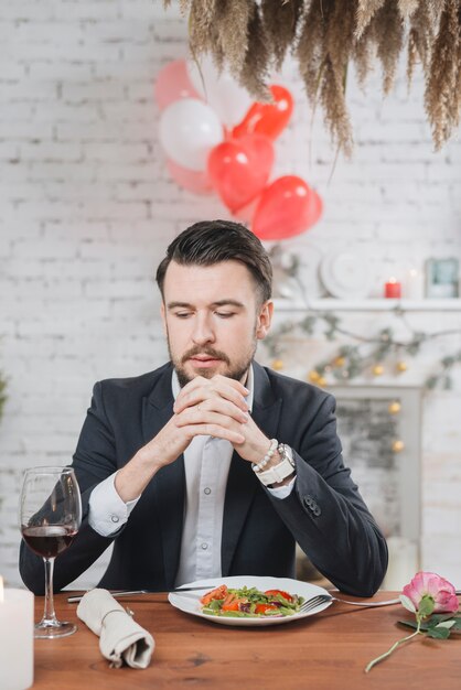 Uomo solo adulto al tavolo con cena romantica