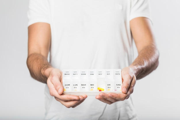 adult male holding pillbox with medicine