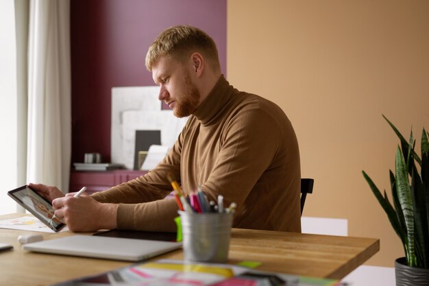 Adult male illustrator working on tablet device