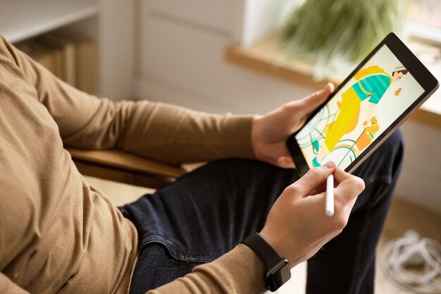 タブレットデバイスで働く成人男性イラストレーター