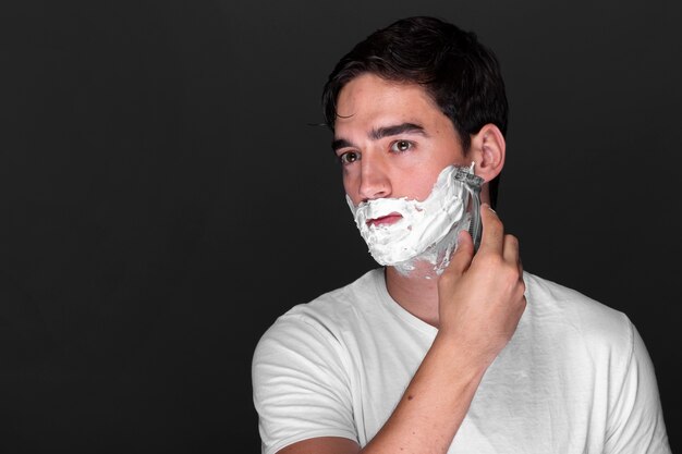 Adult male shaving his beard