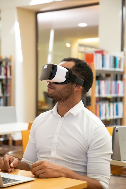 Foto gratuita studente maschio adulto che utilizza l'auricolare vr