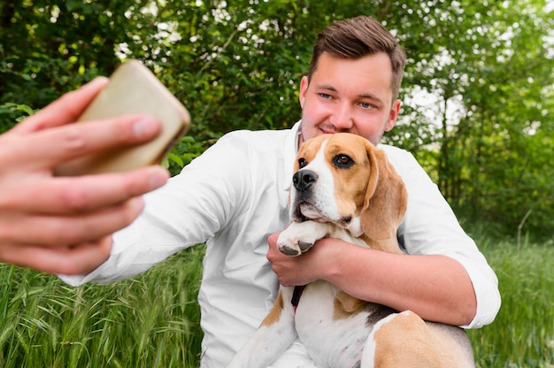 犬と一緒に、selfieを取る成人男性