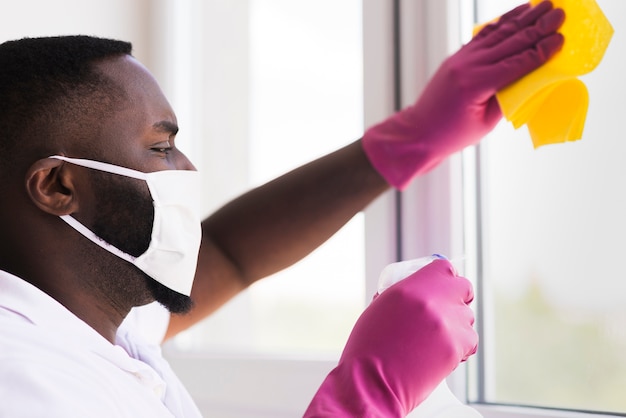 Free photo adult male with face mask cleaning home