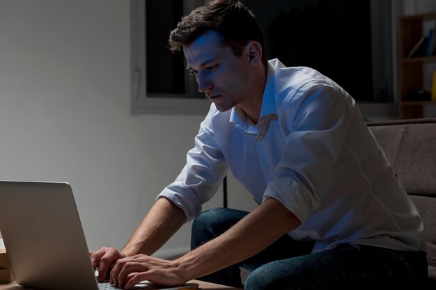 Adult male working on laptop at night