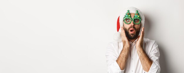 クリスマス パーティーのメガネとサンタの帽子を身に着けている冬の休日を祝う大人の男