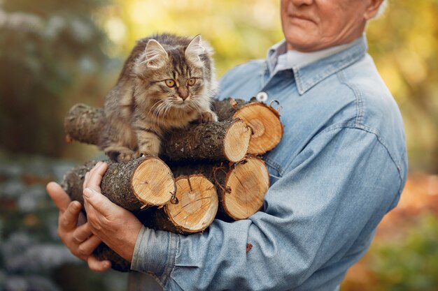 Adult man holding firewood and a cat