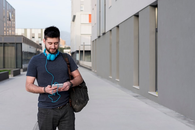 Adult man walking with tablet and headphones