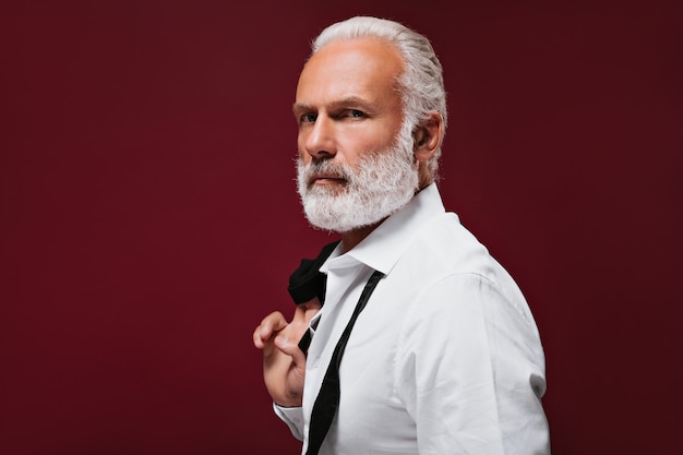 Adult man in white shirt looks into camera